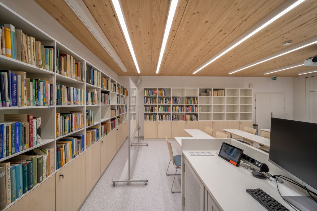 Planung und Einrichtung für modernen Hörsaal mit Schreibtischen und Bücherregalen nach Maß vom Tischler.