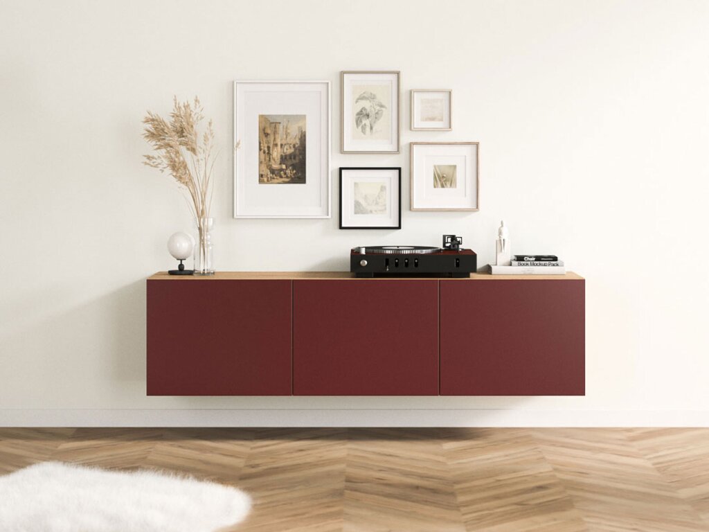 Ein wandgehängtes Sideboard mit einem Rahmen aus rustikalem Eichendekor und matten, rostroten Fronten. Stilvolle Dekoration mit zarten Aquarellbildern, einem Plattenspieler, Büchern und einer Glasvase mit Gräsern.