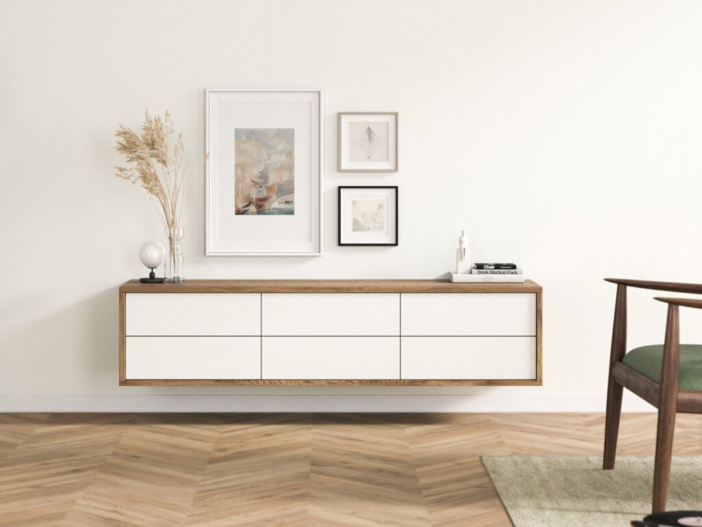 Ein wandgehängtes Sideboard mit einem Rahmen aus rustikalem Eichendekor und weißen Laden. Stilvolle Dekoration mit zarten Aquarellbildern, Büchern und einer Glasvase mit Gräsern.